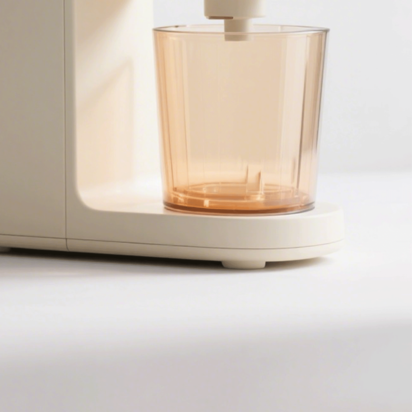 Detalle del exprimidor eléctrico de acrílico con vaso de jugo