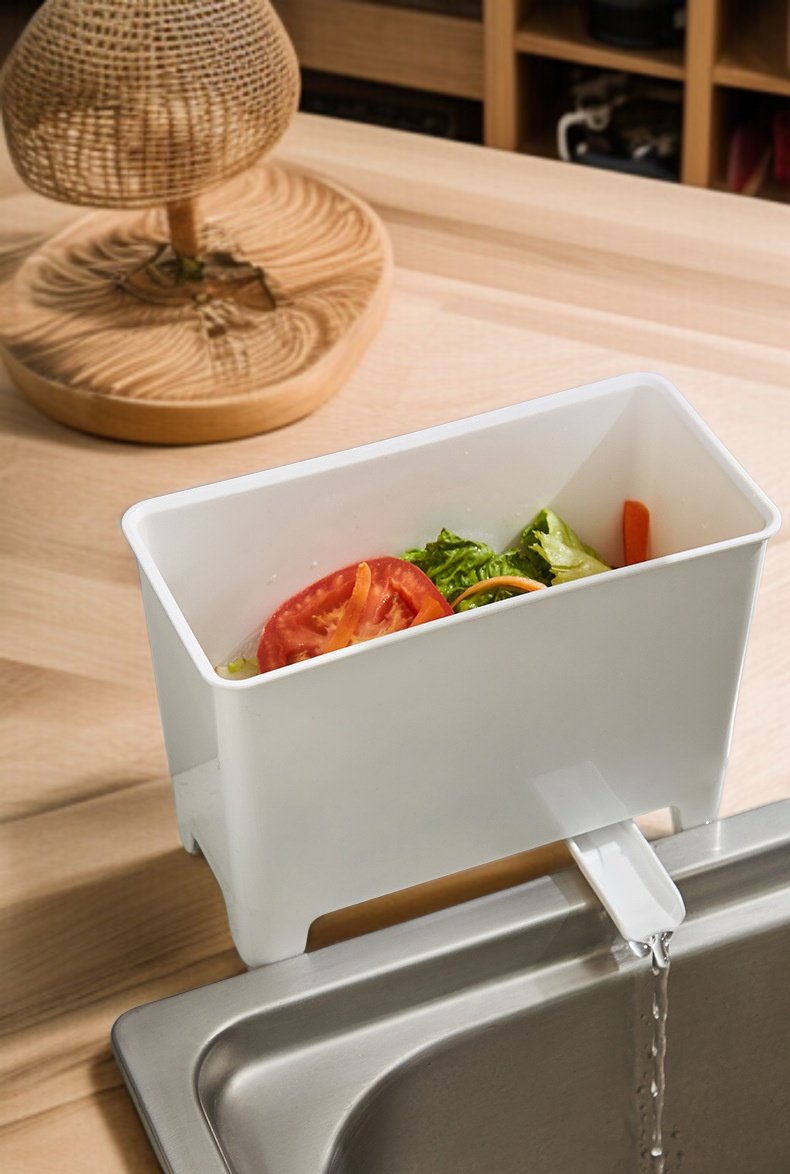 Kuchyňský odpadkový koš vedle dřezu s odkapávajícím odpadem