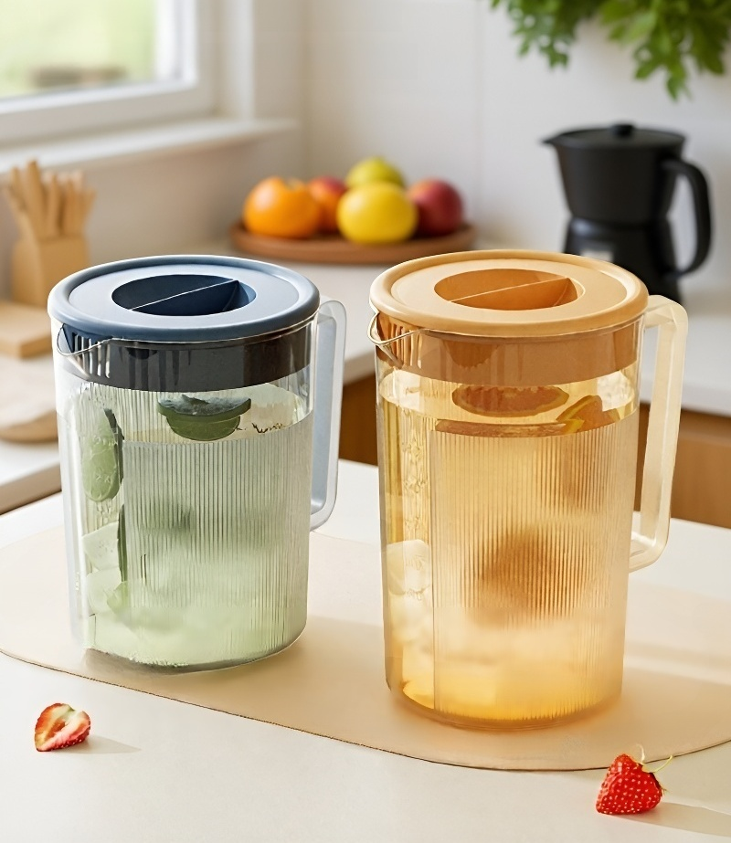 Top view of cold water pitcher pouring into drinking glass