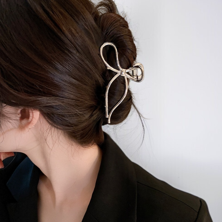 Hair at the back of the head is clamped with a bow metal clip