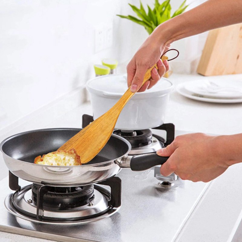 Palas de madera, ollas, palas, vajilla y Verduras fritas