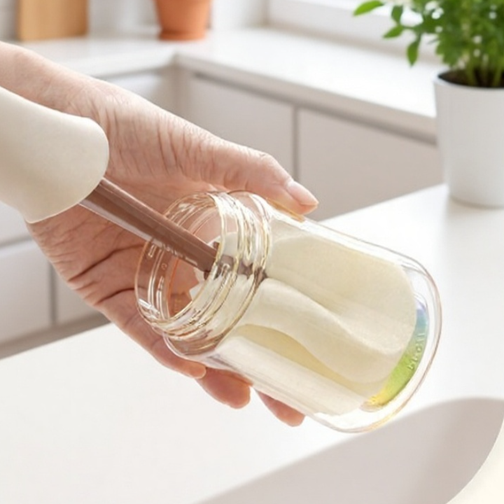 Sponge brush cleaning the inside of a glass cup