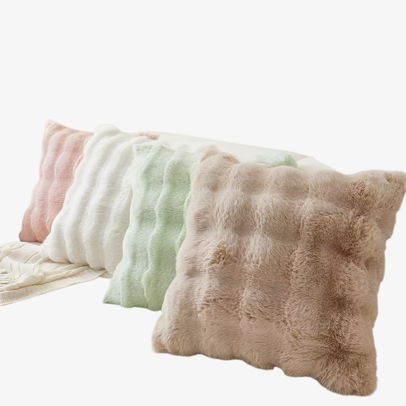 Cojín decorativo de imitación piel de conejo sobre cama