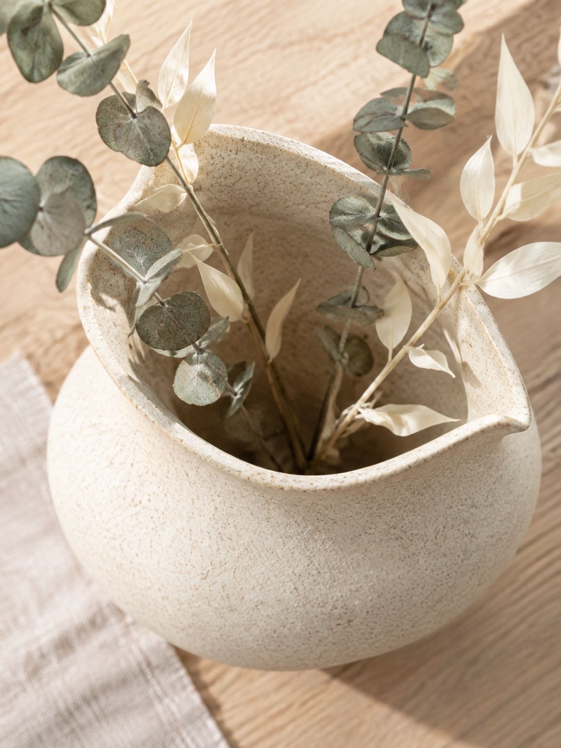 Mélange artistique : vase en céramique Misu avec des plantes décoratives.