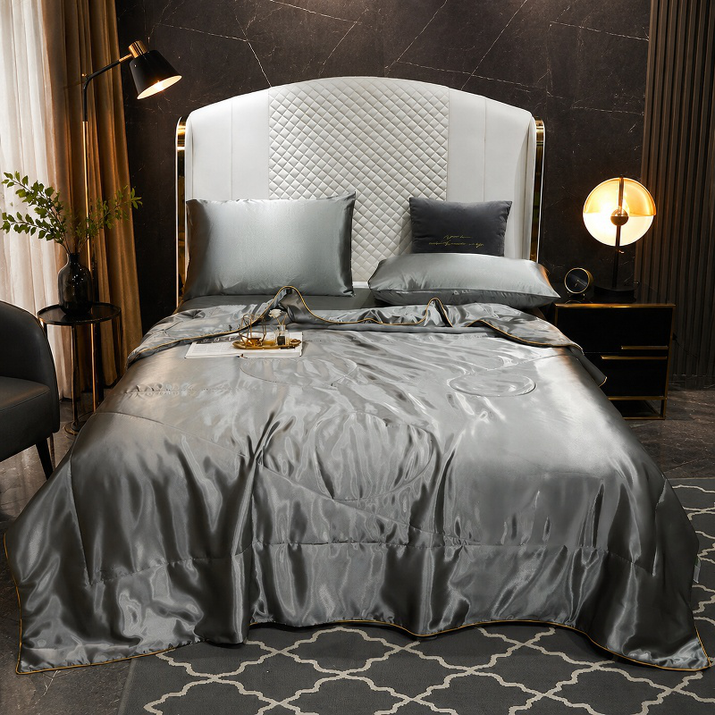 Elegant white silk quilt cover draped on bed