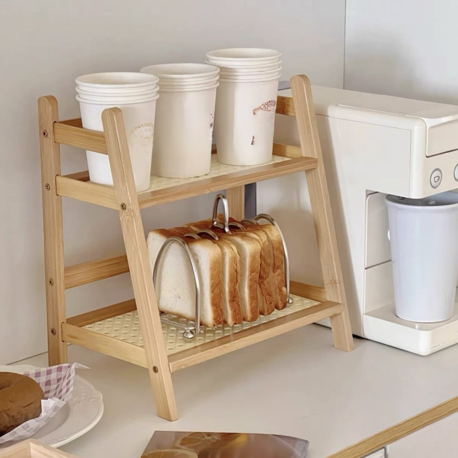 床置き型の多段式卓上台形棚／本棚。プラスチック製のラタン素材を組み合わせ、クリーム色のスタイルで家庭のキッチンに最適です。